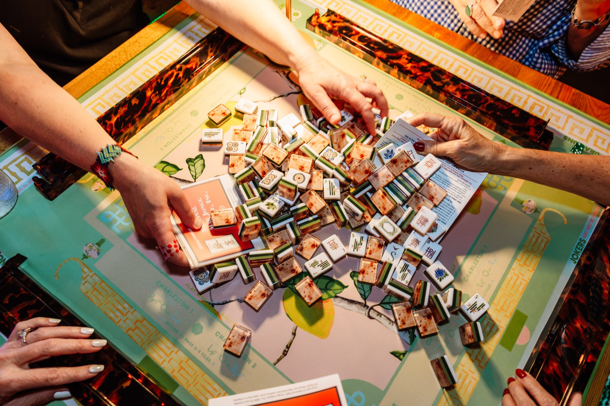 Players around a mahjong table at an Open Play night